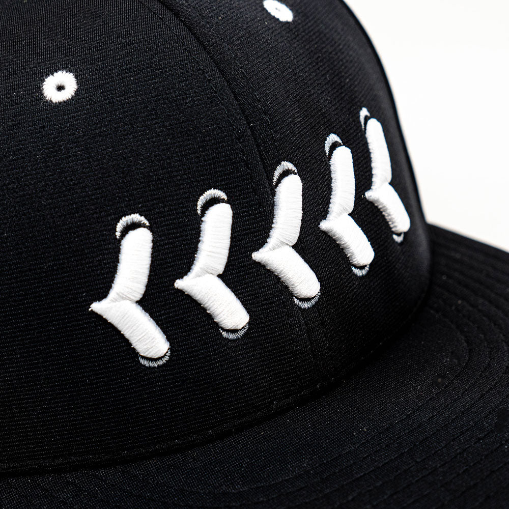 Closeup of white stitching on black fitted hat