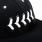 Closeup of white stitching on black fitted hat