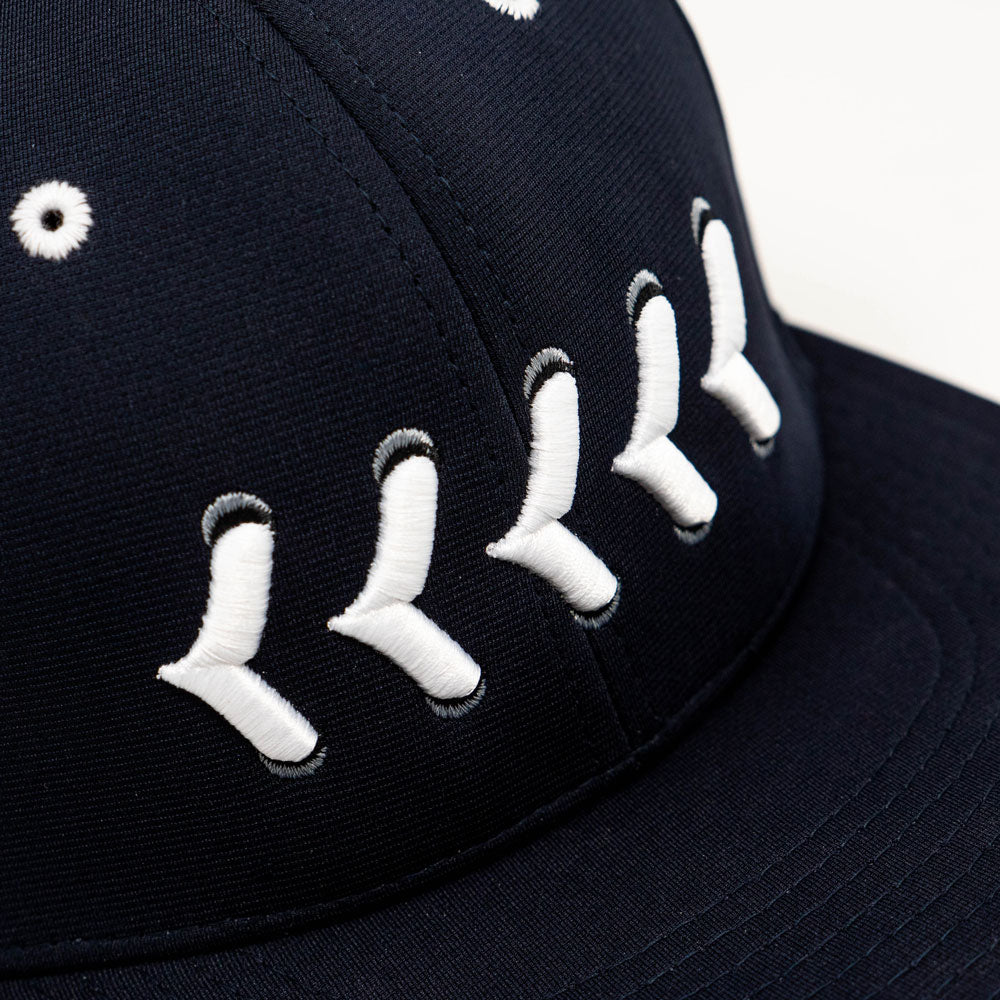 Close up of white stitching on navy fitted hat